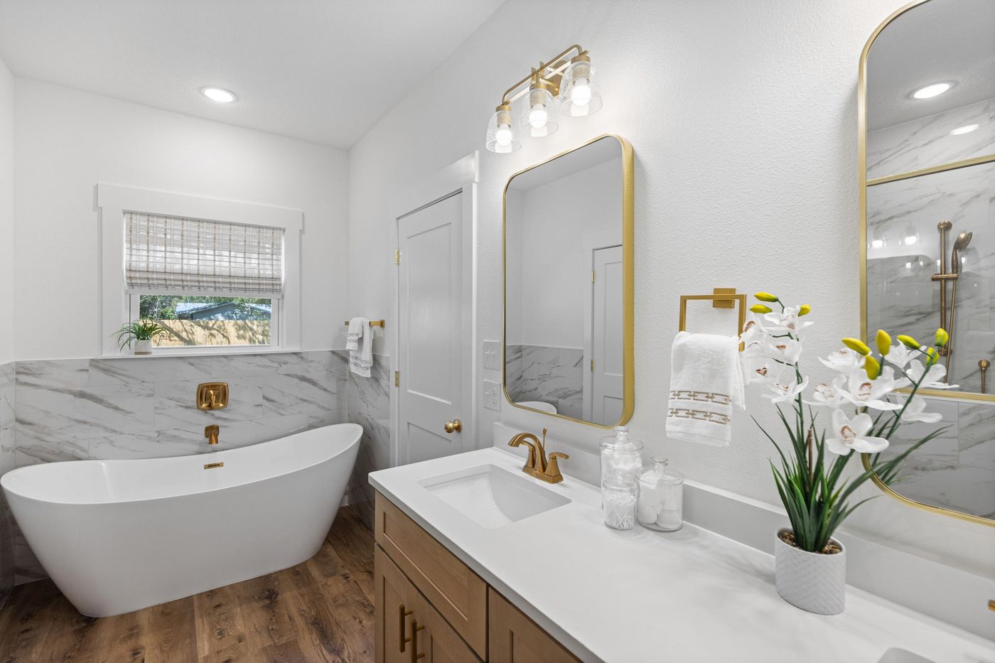 Primary bath with a freestanding tub and gold fixtures